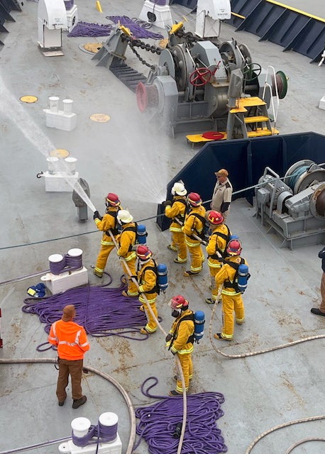 Cadets participating in a live fire drill on the deck of the Training Ship Golden Bear.