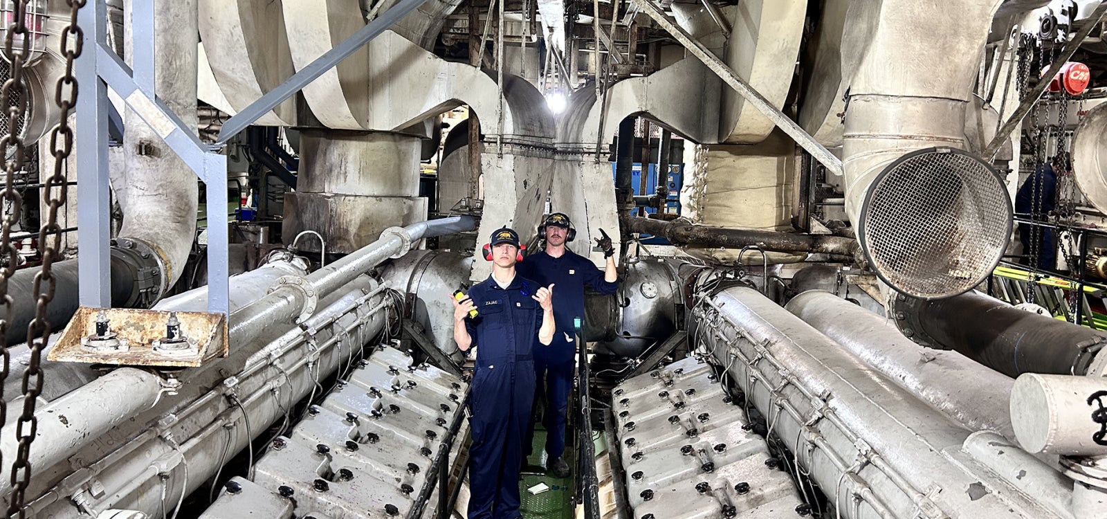 Two cadets pose in the working of the ship