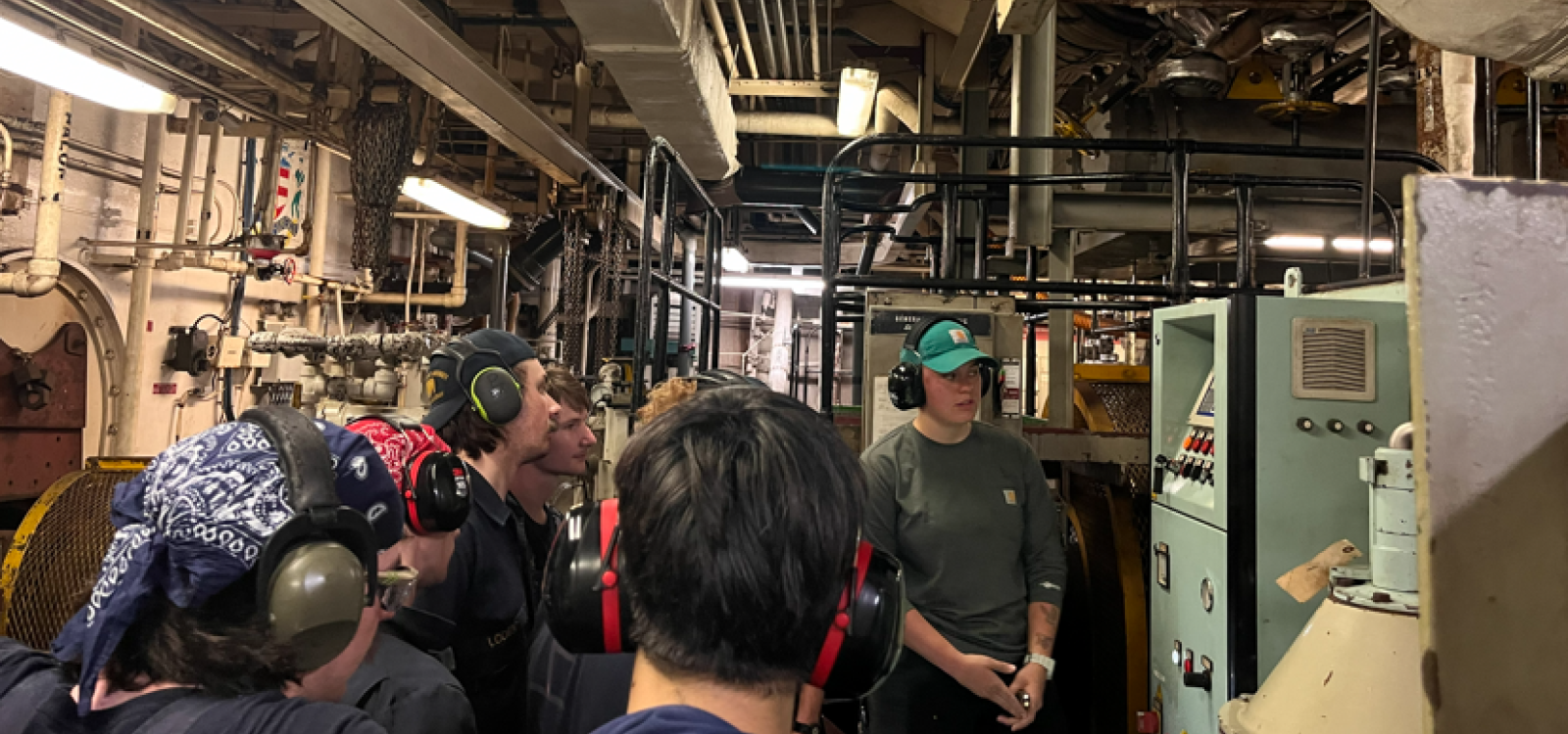 License Watch Officer Jessica Hebert explains the fundamentals of the oil-water separator system to cadets standing watch.  Photo by Maria "Maya" Barrozo, assistant purser, TSGB