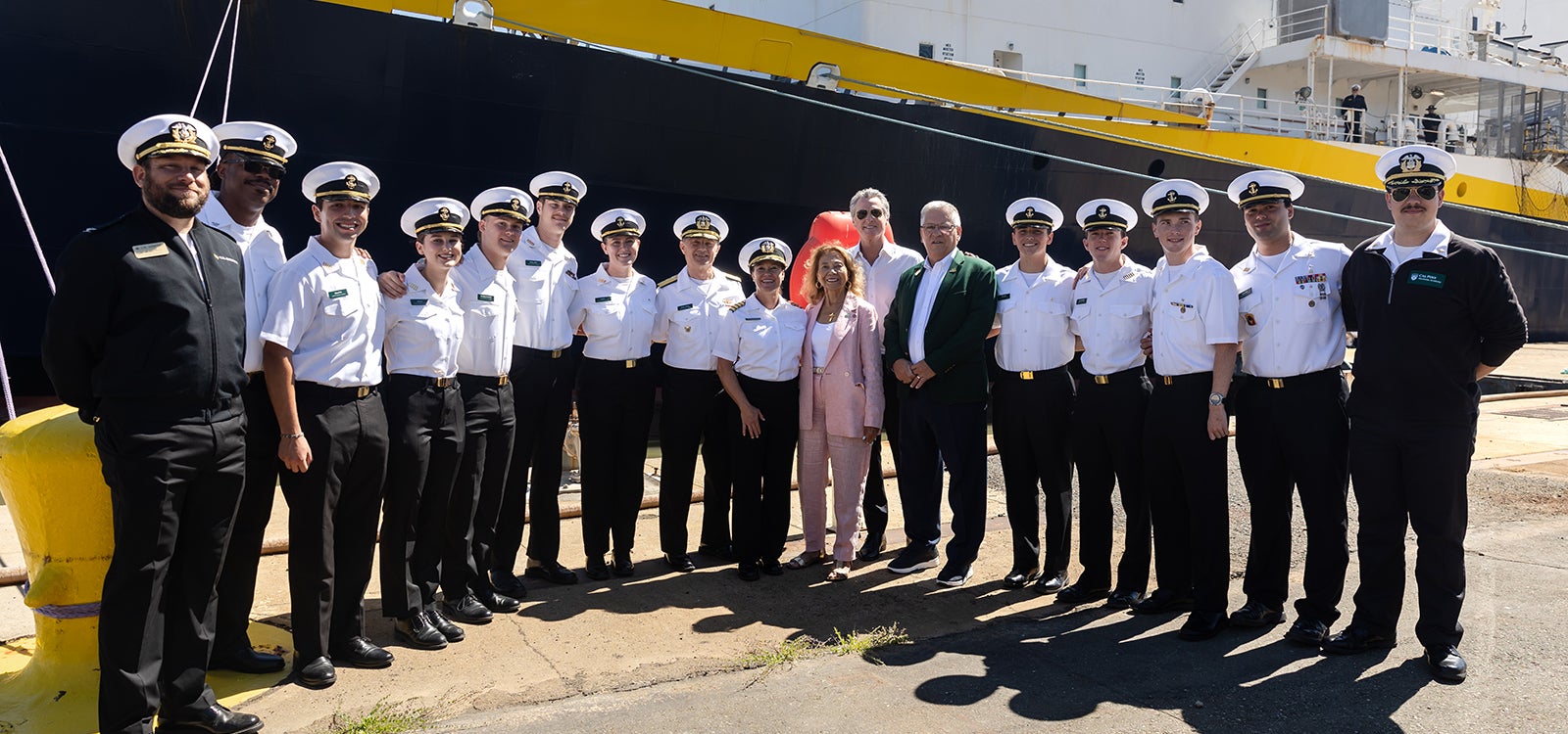 Cadets standing with Gov. Gavin Newsom and other leaders in front of the Training Ship Golden Bear.