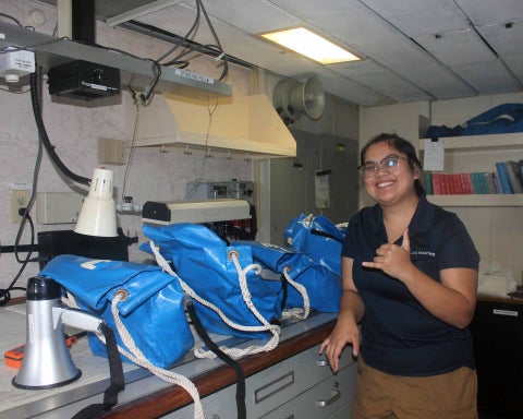 Cadet Barrozo creating bag lunches for whales while enroute to Fiji.  