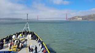 The Training Ship Golden Bear sailing toward the iconic Golden Gate Bridge and into the Pacific Ocean, where the voyage and the adventure truly begin.