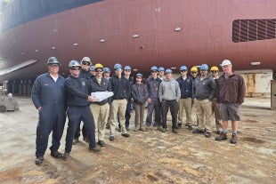 Cal Poly Maritime Academy students standing in front of R/V Sally Ride.