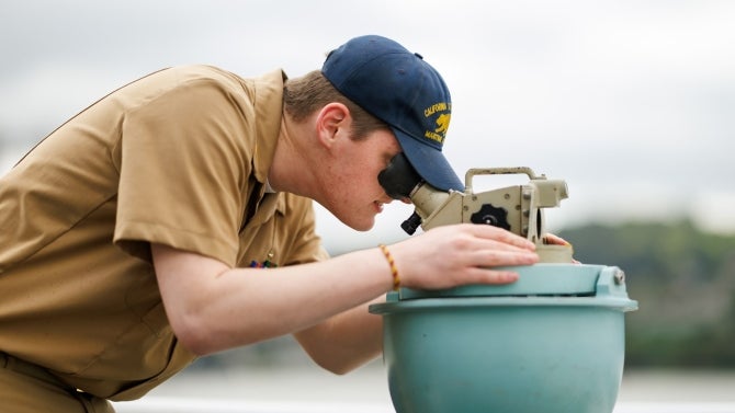 Student uses nautical tool at sea