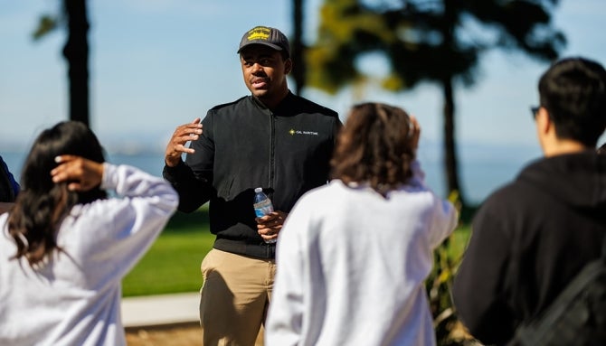 An instructor speaks with a group of students