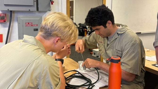 Two students work on device