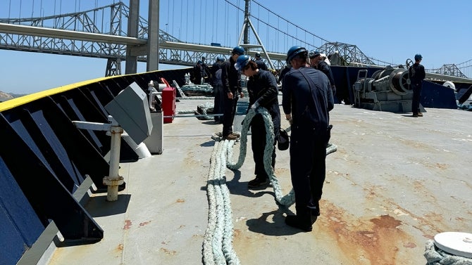 Students in hard hats work on vessel