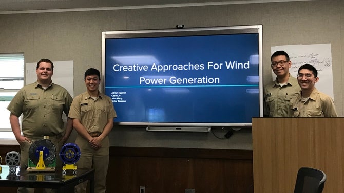 Four students pose for photo during research presentation
