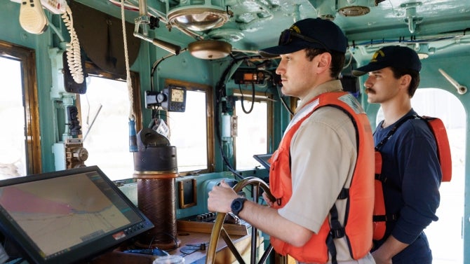 Two cadets look to sea while at helm of TS Golden Bear